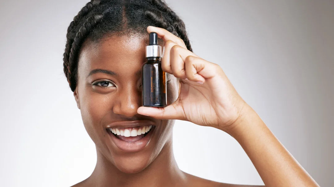 A woman showcasing a bottle of retinol oil, highlighting its skincare benefits for a youthful appearance.