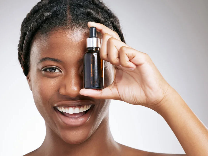 A woman showcasing a bottle of retinol oil, highlighting its skincare benefits for a youthful appearance.