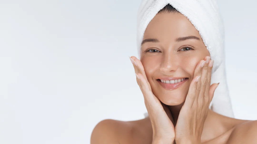 A smiling woman with a towel on her head, showcasing the benefits of Hyaluronic Acid Cream for radiant skin.