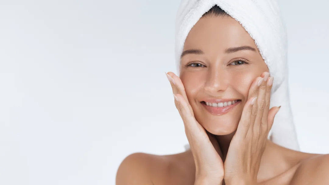 A smiling woman with a towel on her head, showcasing the benefits of Hyaluronic Acid Cream for radiant skin.